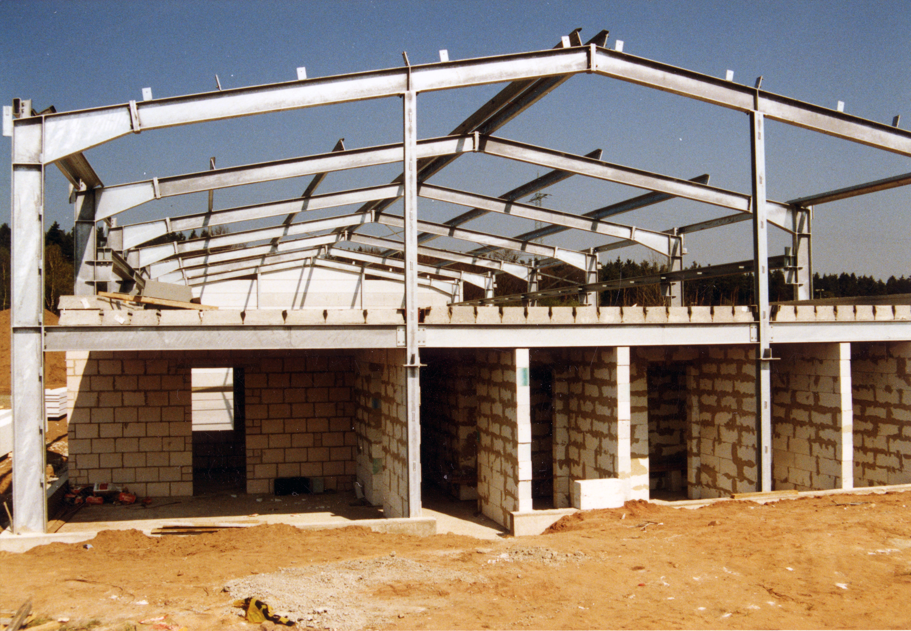Lagerhalle in Konstruktion. Die unteren Wände stehen, oben ist noch alles offen.