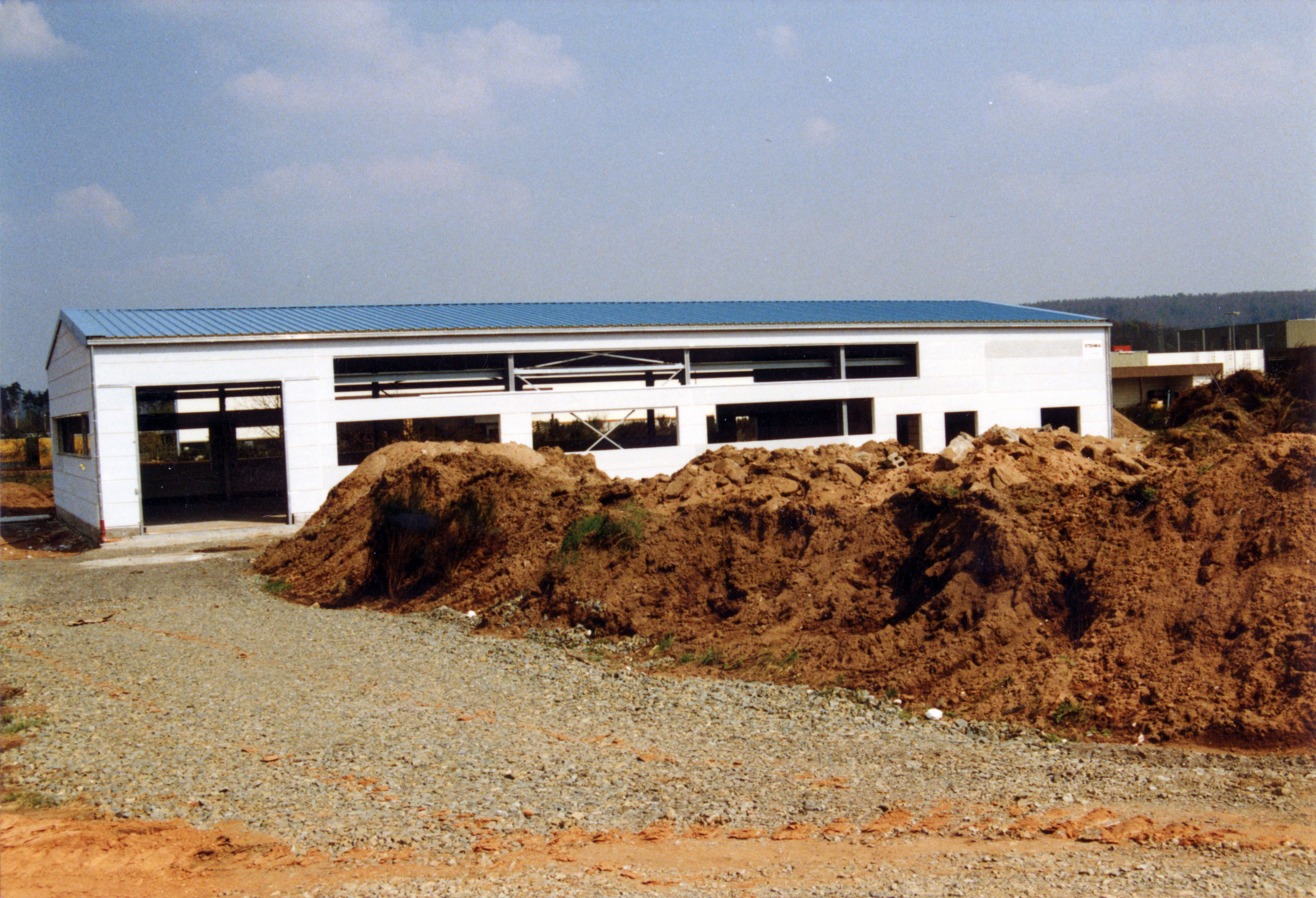 Lagerhalle von Außen mit einem großen Garagen artigem Eingang Links.