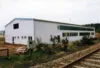 Lagerhalle von außen. Vorne dran verlaufen Schienen.