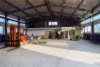 Lagerhalle mit Gabelstapler und verschiedene Maschinen.