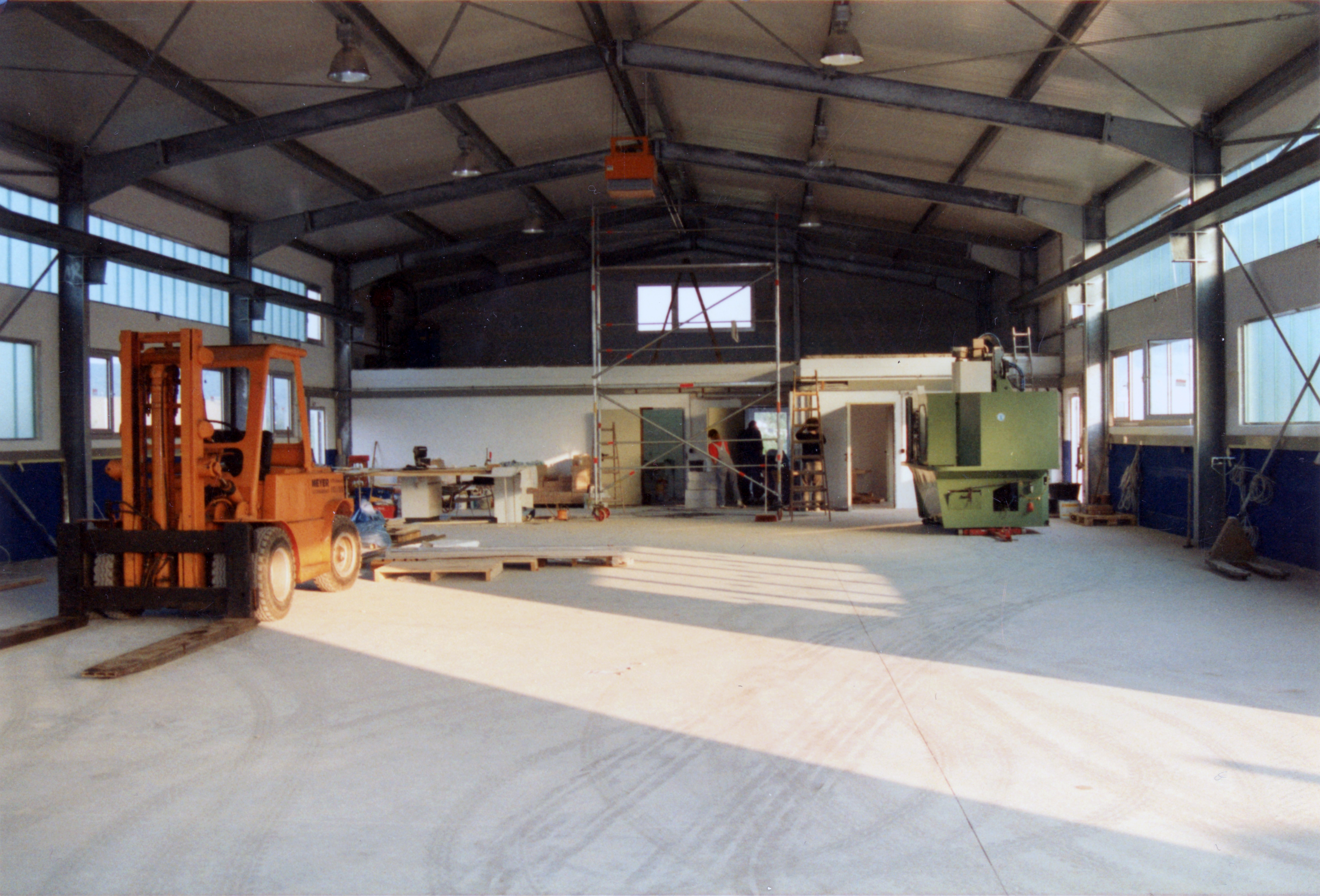 Lagerhalle mit Gabelstapler und verschiedene Maschinen.